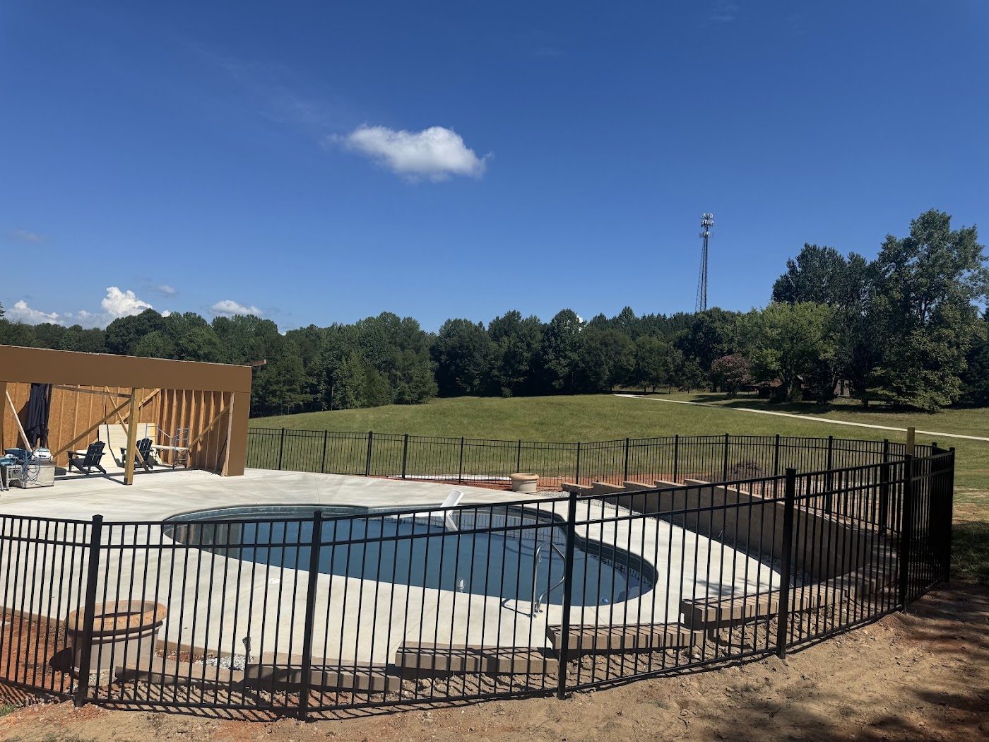 Black ornamental aluminum fence around an in-ground pool
